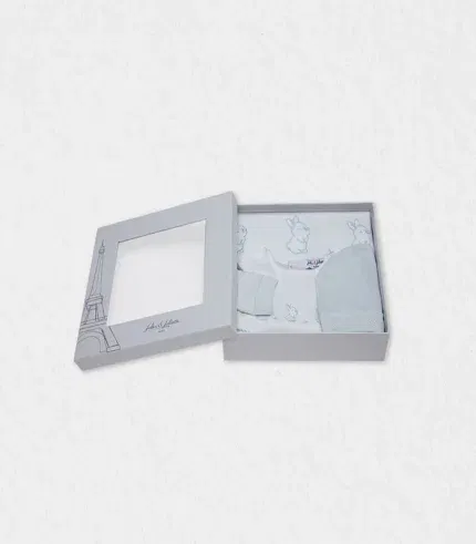 Flat-lay of organic-cotton pyjama, blanket and hat arranged beside our Eiffel-Tower gift box, showing pastel bunny embroidery—baby gift set ready for Dubai baby showers yet shipped worldwide to delighted parents seeking premium newborn essentials.