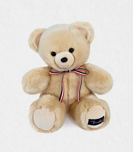 Lifestyle shot of the handmade teddy bear seated in a pastel nursery, illustrating its perfect size for newborn hugs and nursery decor—handmade teddy bear Dubai baby gift shipped worldwide